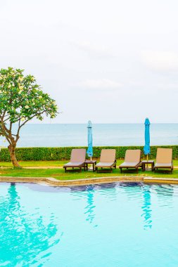 Sandalye havuzu ya da yüzme havuzu etrafında şemsiye olan yatak havuzu