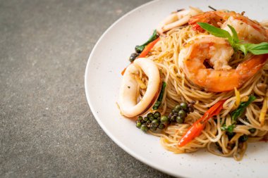 Fesleğenli, biberli, karidesli ve kalamarlı Çin eriştesi. Asya usulü.