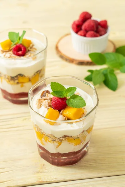 Ev yapımı taze mango ve yoğurt ve granola ile taze ahududu. Sağlıklı yemek tarzı.