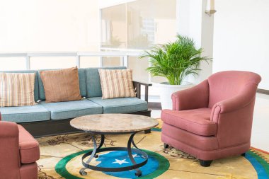 Boş kanepe ve yastıklı sandalye bir odada.