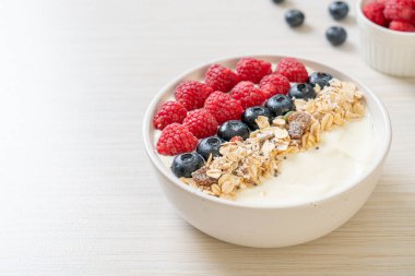 Ev yapımı yoğurt kasesi, ahududu, yaban mersini ve granola. Sağlıklı yemek tarzı.