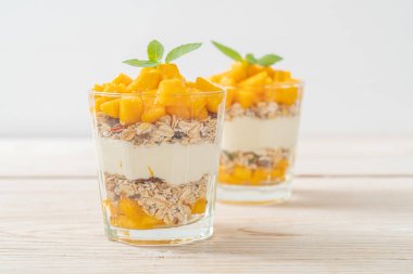 Taze mangolu yoğurt ve camlı granola. Sağlıklı yemek tarzı.