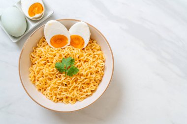 Hazır erişte kasesi ve tuzlu yumurta.