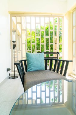 Balkondaki teras sandalyesinde rahat yastık süslemesi