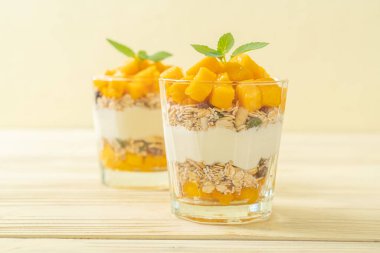 Taze mangolu yoğurt ve camlı granola. Sağlıklı yemek tarzı.