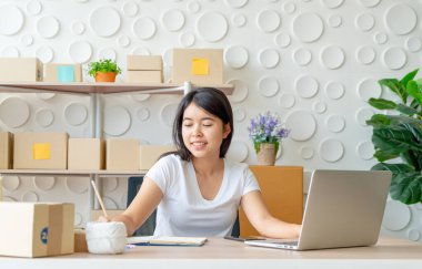 Genç Asyalı kadın, işyerinde dijital tabletle çalışan küçük bir işletme sahibi kuruyor - İnternet satışı, e-ticaret, nakliye konsepti