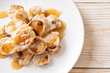 Izgarada dilimlenmiş muz ve karamel sosu.