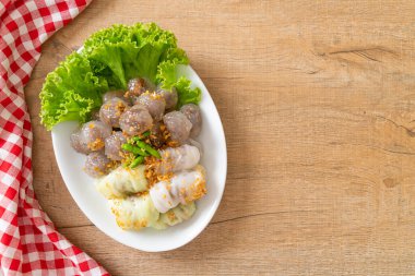 Şeffaf toplara Saku Sai Moo ya da Buharlı Tapioca Köfte Topları ve (Kow Griep Pag Mor) Domuz Buharlı Pirinç Paketleri ya da Haşlanmış Pirinç Kabuklu Mantı denir.