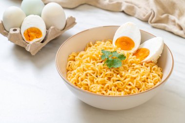 Hazır erişte kasesi ve tuzlu yumurta.