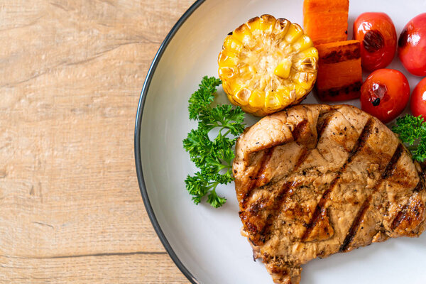 grilled and barbecue fillet pork steak with corn, carrot and tomatoes