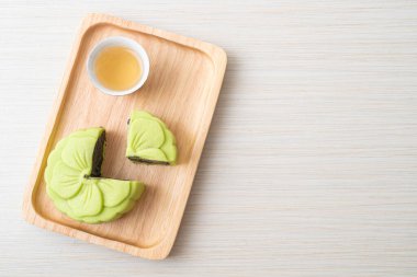 Çin ay çöreği yeşil çay aromalı ahşap tabakta çay