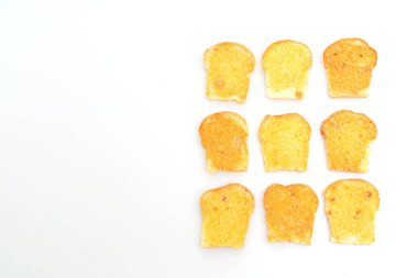 Beyaz zemin üzerinde tereyağı ve şeker ile pişirilmiş çıtır ekmek