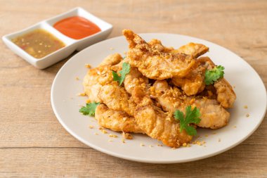 Tabakta sarımsaklı kızarmış balık.