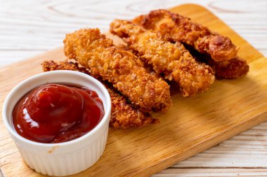 Ketçaplı kızarmış tavuk çubuğu.