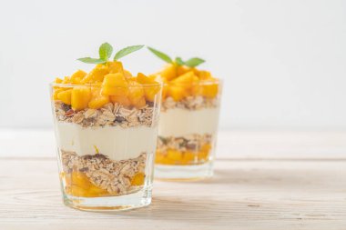 Taze mangolu yoğurt ve camlı granola. Sağlıklı yemek tarzı.