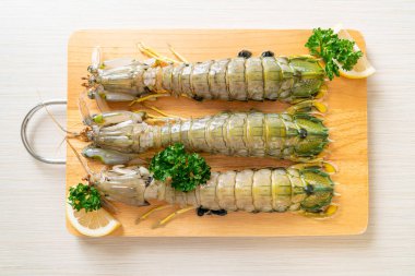 Tahtada limon olan taze peygamber devesi karidesi.