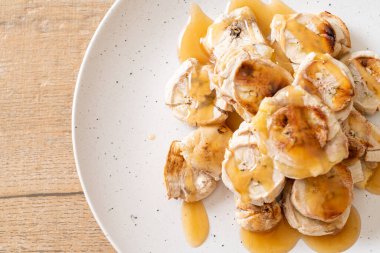 Izgarada dilimlenmiş muz ve karamel sosu.