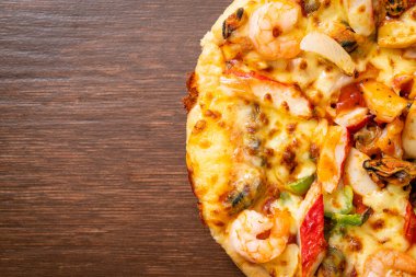 Tahta tepside deniz ürünleri (karides, ahtapot, midye ve yengeç) pizza