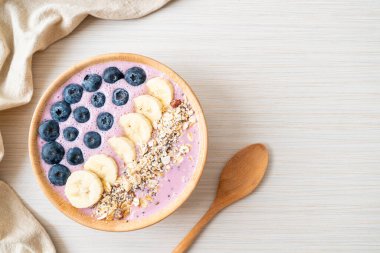 Yoğurt ya da yoğurtlu smoothie kasesi, böğürtlen, muz ve granola.