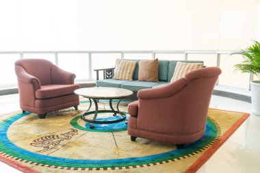 Boş kanepe ve yastıklı sandalye bir odada.