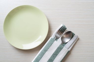 Ahşap zemin üzerinde bıçak, çatal ve kaşık olan boş tabak veya tabak