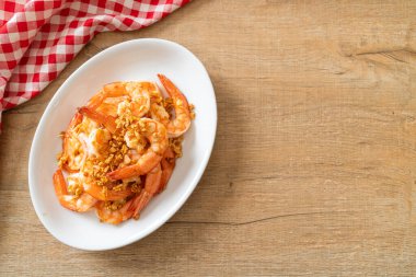 Kızarmış karides ya da beyaz tabakta sarımsaklı karides - deniz ürünleri tarzı.