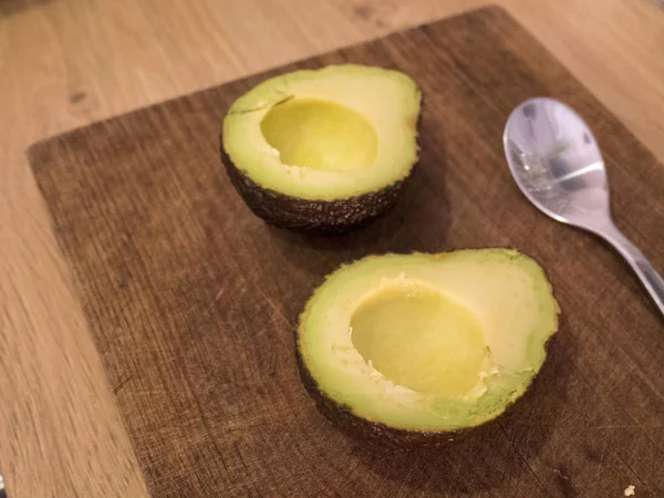 Rijpe avocado gesneden in twee klaar om te worden gegeten — Stockfoto
