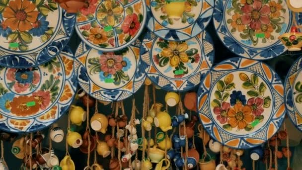 Tracking shot typical hand-painted majolica plates hung in a market in Valencia, Spain — Stock Video