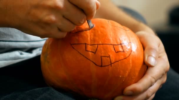 Esculpir uma abóbora para o Halloween com uma faca — Vídeo de Stock