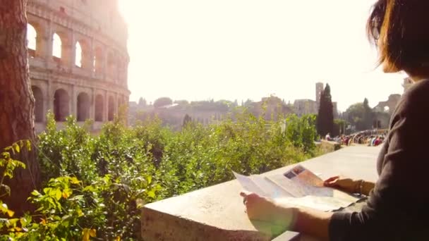 Γυναίκα μοιάζει στο τουριστικό χάρτη μπροστά από το μεγαλοπρεπές Κολοσσαίο στη Ρώμη — Αρχείο Βίντεο