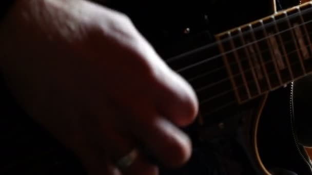 Detalj av en hand av en pojke som spelar akustisk gitarr i hans rum — Stockvideo