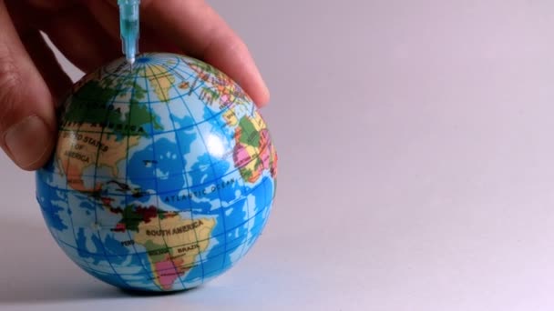 Plastikspritze spritzt Gift in einen Globus, ideales Filmmaterial zur Erklärung ökologischer Probleme — Stockvideo