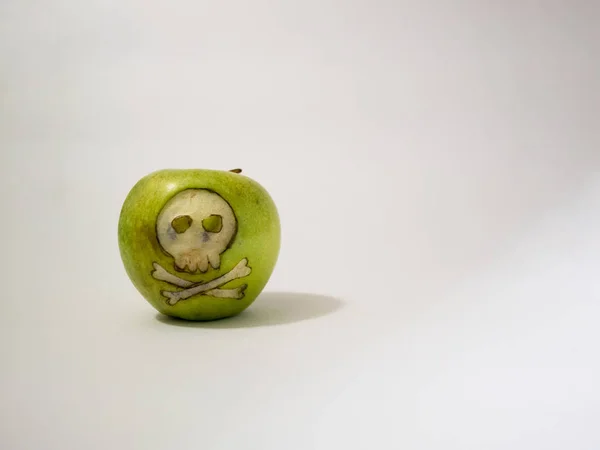 Maçã verde com crânio gravado, imagem representativa do uso de substâncias gmo em alimentos — Fotografia de Stock