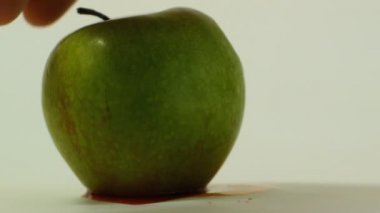 bir el bir kazıma kanlı kafatası, GDO maddelerin gıda, sebze ve meyve kullanımı temsil edici bir görüntü ile bir yeşil elma turnike