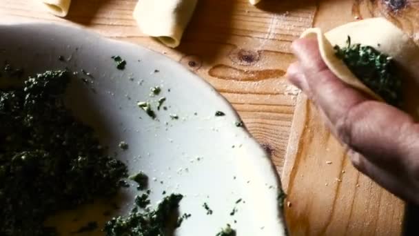 Detalle de la mano de una dama italiana que prepara ravioles, llenándolos de espinacas y ricotta — Vídeos de Stock