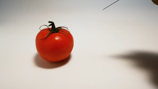 Inyecta una jeringa con gmo líquido verde en un tomate sobre un fondo blanco — Vídeos de Stock