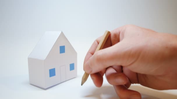 Main dessine un cercle jaune à côté d'une maison en papier acheter symbole de la maison — Video