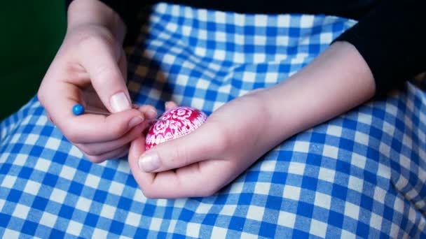 Detalle de las manos de niña, que graba adornos de Pascua en huevos de colores, con técnica de grabado, costumbre típica de Europa del Este — Vídeos de Stock
