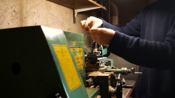 Apasionado hombre de bricolaje, utiliza el torno para bricolaje, en su laboratorio en casa, el trabajo de precisión con torno de metal — Vídeos de Stock