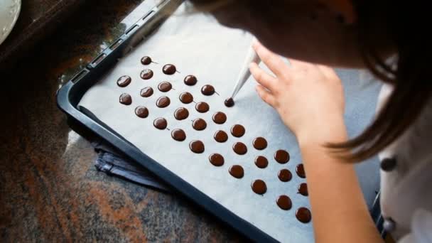 Pastelería joven hace barras de chocolate con una bolsa de pastelería, ideal para representar la pastelería casera — Vídeos de Stock