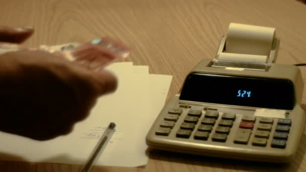 Oude led rekenmachine met PRINTERLINT papier en handen tellen van geld, beelden te vertegenwoordigen concepten van economie en Financiën — Stockvideo