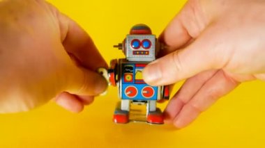 adam onu sarı arka plan görüntüleri yenilik, teknoloji gibi konular için ideal yürüyüş yapmak için vintage bir metal robot yükler
