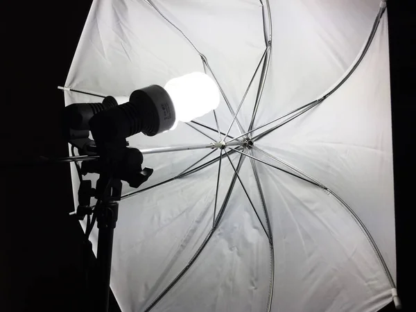 Luz profissional em um tripé com guarda-chuva no processo de tiro, aparelho de tv — Fotografia de Stock