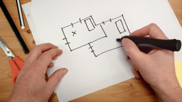 Ovanifrån, en hand som inredningsarkitekter ritar en idealisk karta för nya hem, bilder perfekt för ämnen såsom byggnadsutformning, renovering, nya hem och familj — Stockvideo