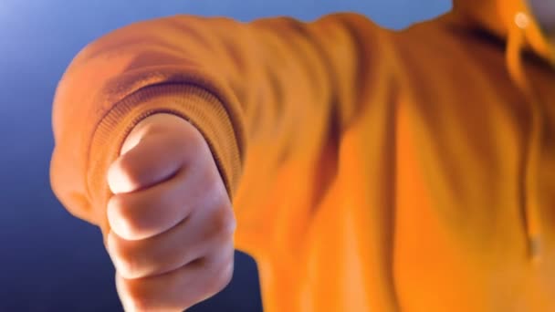 Дівчина-підліток з помаранчевим светром, вона робить як і не любить з її рукою — стокове відео
