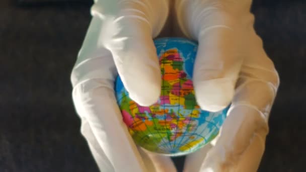 Teenagermädchen hält mit weißen Handschuhen eine Weltkugel in der Hand, ideales Filmmaterial, um ökologische Themen darzustellen — Stockvideo