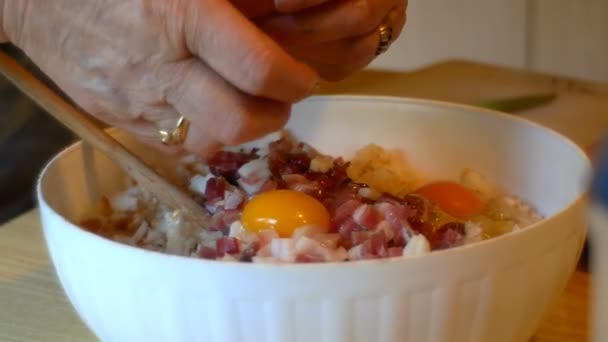 Uma cozinheira, ela coloca os ovos e speck em pequenos cubos na massa dos bolinhos tiroleses — Vídeo de Stock