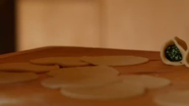 Yaşlı kadın ustaca bir şekilde ıspanak ile ravioli doldurur