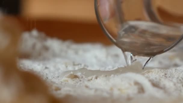 Elderly woman puts water in the flour — Stock Video