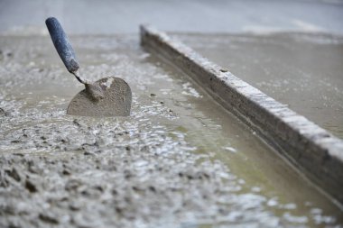 Construction trowel in cement mortar